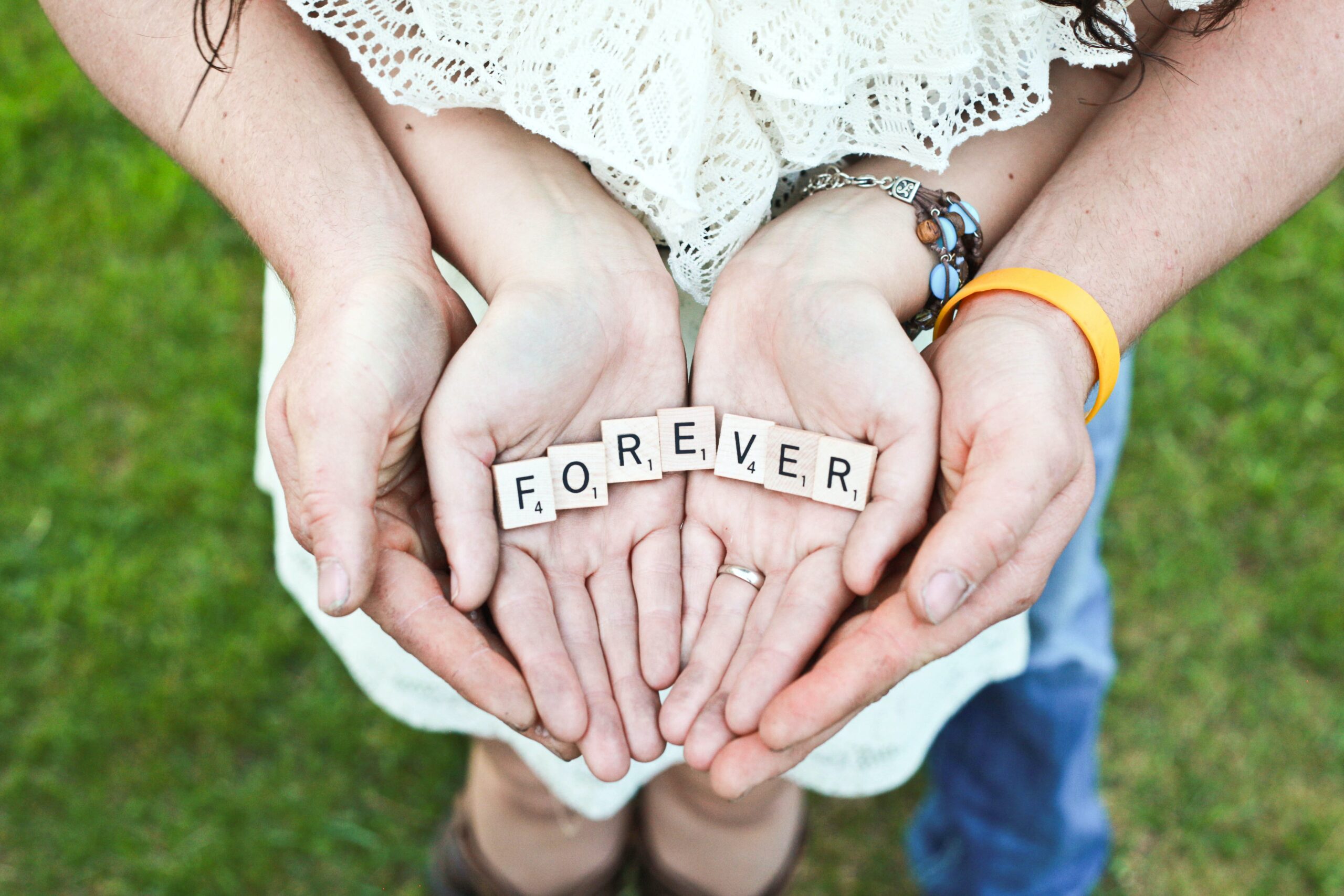 Photo of adult and girl holding scrabble letters during day time