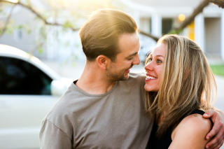 Picture of Man in grey crew shirt kissing woman in black top