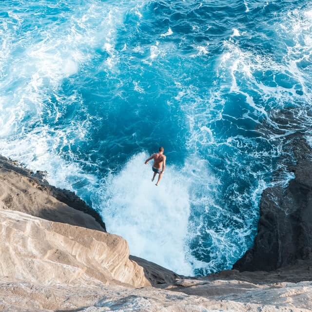 Picture of man jumping off of Hawaii Cave - About Guidebyday