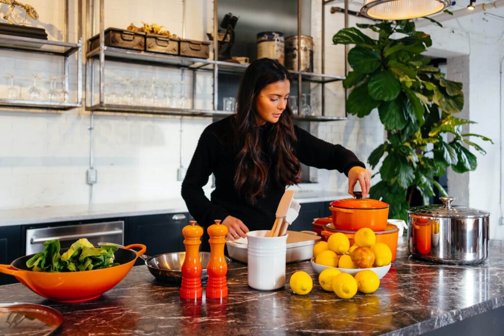 Picture of Women cooking in kitchen beside green plant