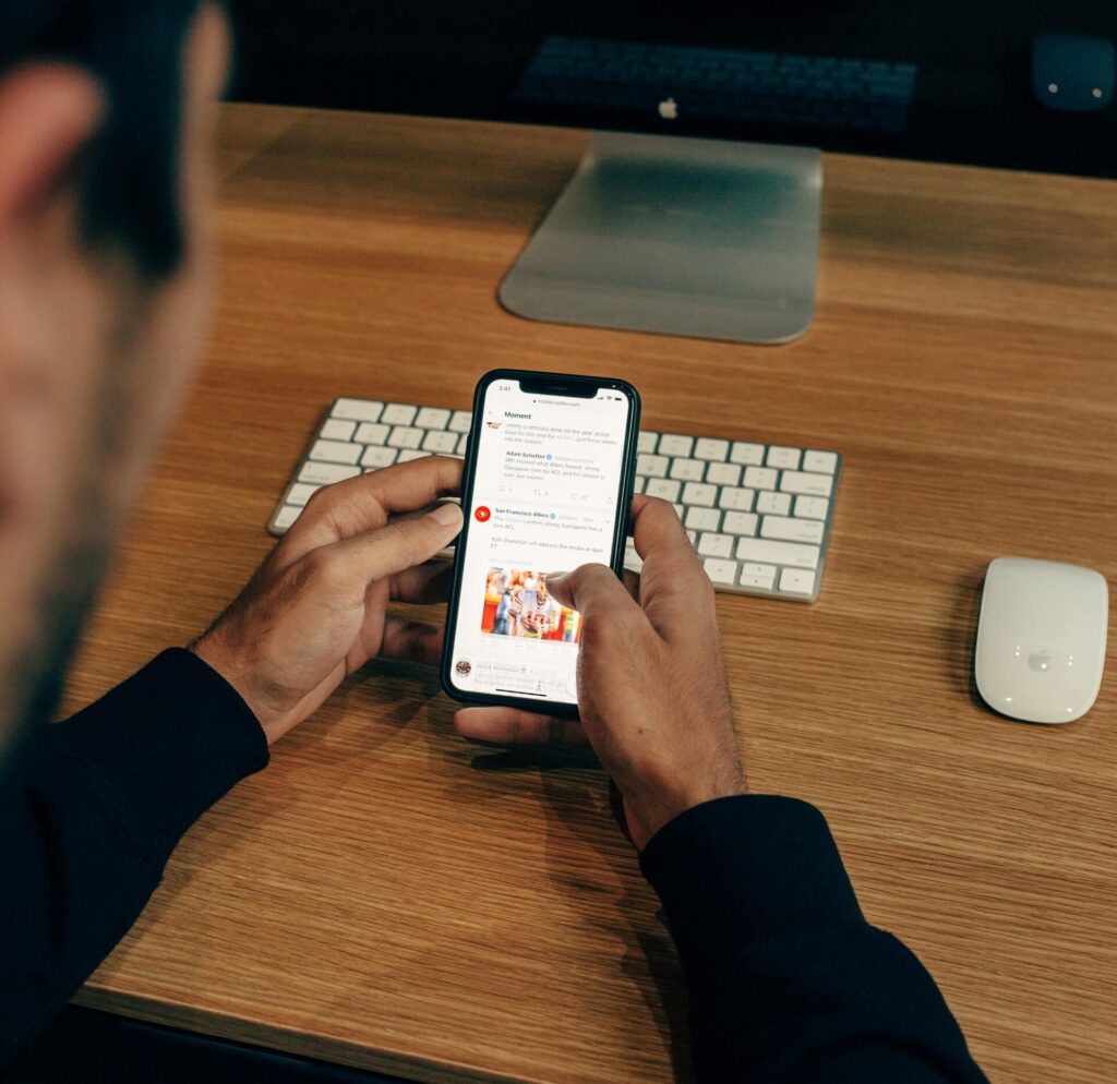 Picture of Man Using Phone on Desk - Social Marketing