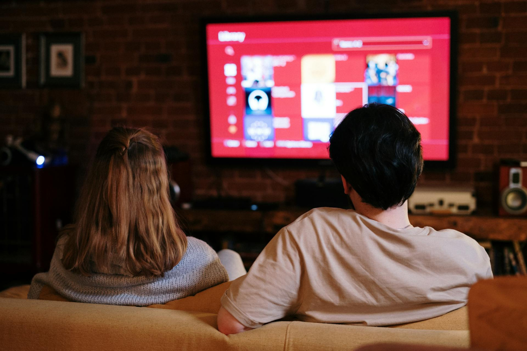 Picture of couple sitting in home for watching movie together