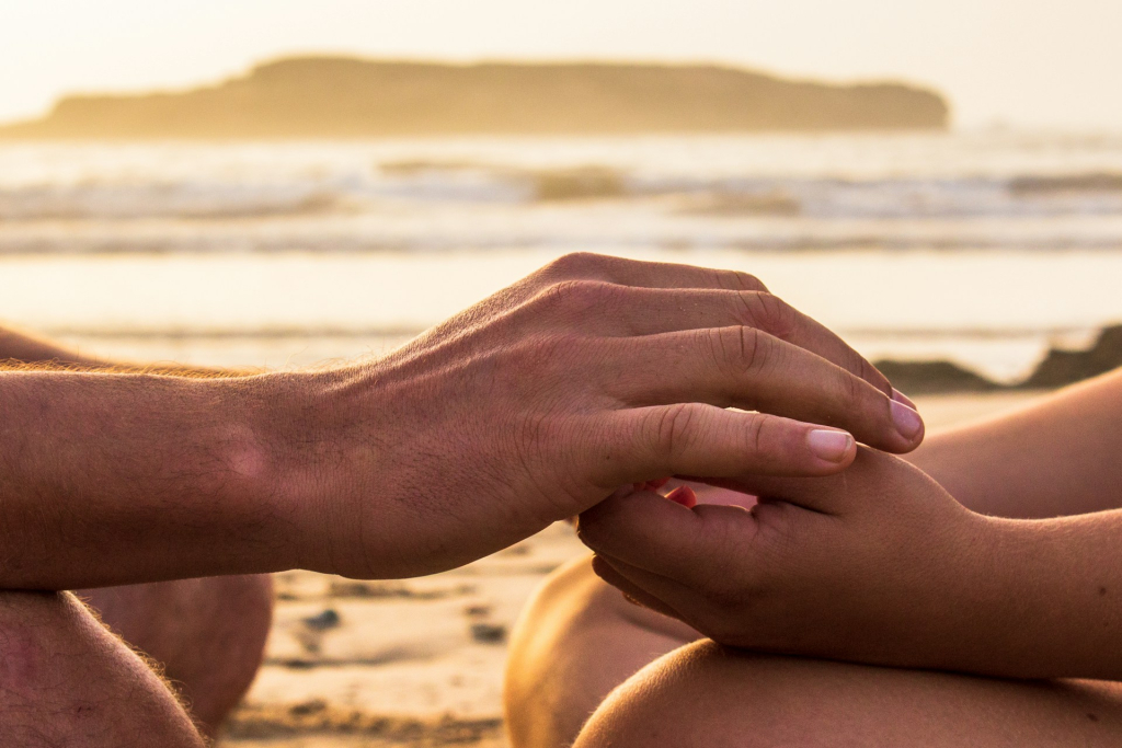 Picture of couple meditating near ocean