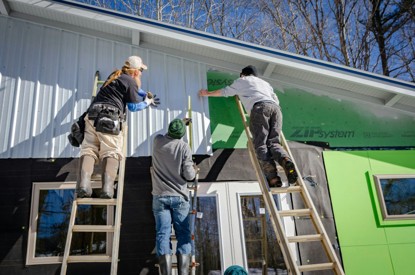Picture of three persons installing metal roof