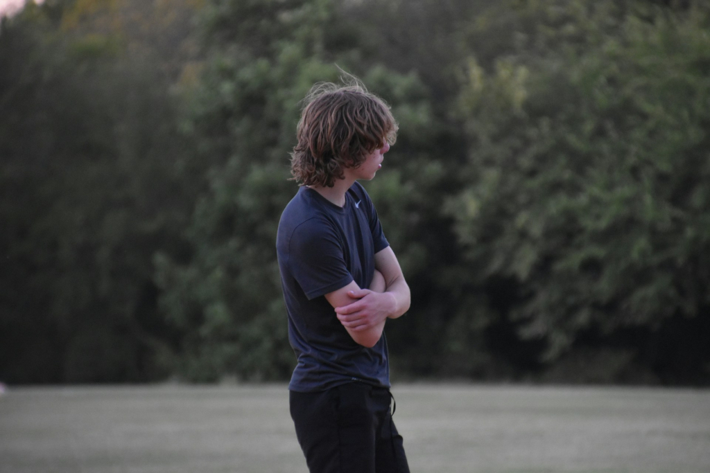 Picture of teen boy standing in the field in blue t-shirt