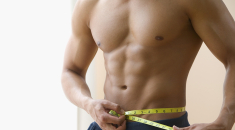 Picture of muscled man measuring waist with tape
